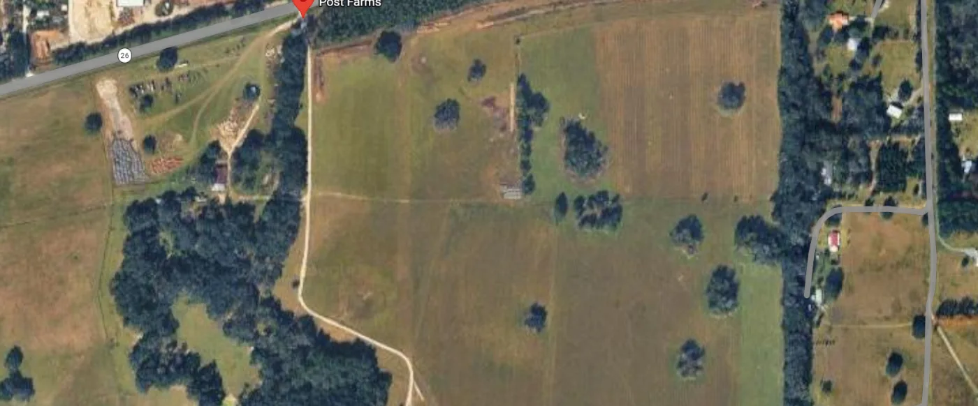 Post Farms from above — the open field, the tree line and the highway along its north edge